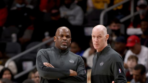 Atlanta Hawks head coach Nate McMillan confers with assistant coach Chris Jent during their game against the LA Clippers at State Farm Arena.